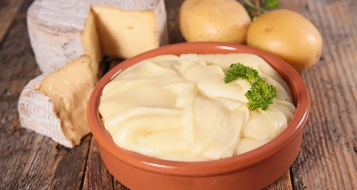 Aligot receta: puré cremoso de patatas y queso, con patatas y queso de cabra al lado.