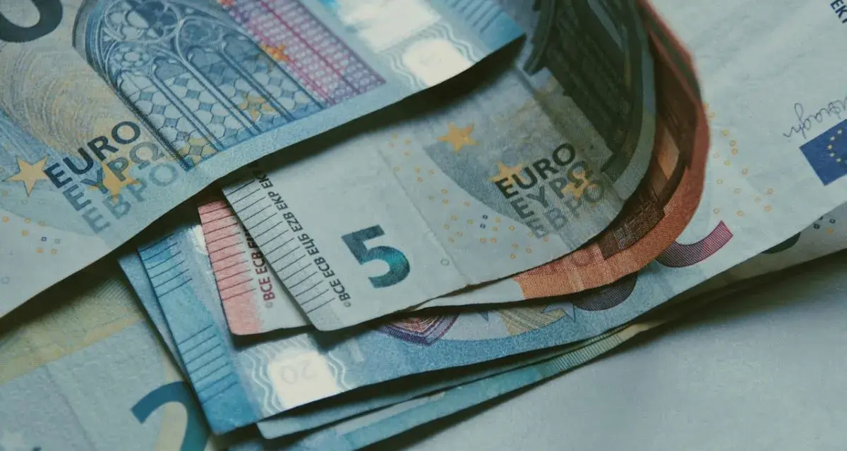 Euro banknoty, w tym 5, 20 i 50 euro, leżące na stole. Zastanawiasz się, jak rozliczyć się z ubezpieczenia w Holandii?