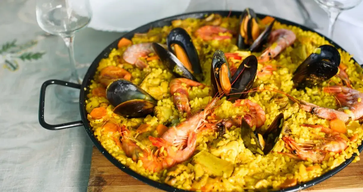 Pyszna paella z owocami morza, idealne hiszpania jedzenie. Krewetki i małże na żółtym ryżu.