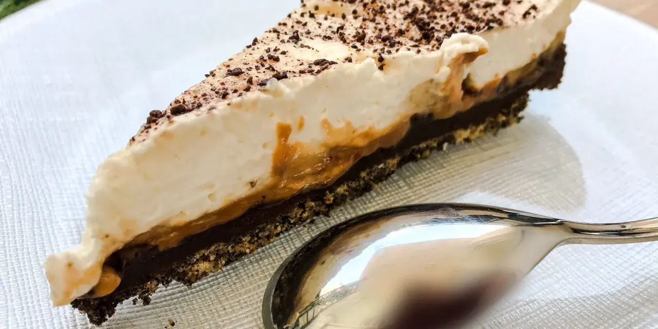 Pyszny kawałek banoffee pie z karmelem i bitą śmietaną, posypany czekoladą. Czy to lepszy wybór niż tarta cytrynowa?