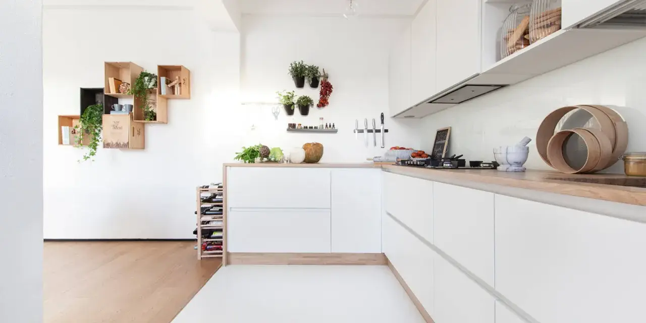 Progetto cucina angolare piccola: mobili bianchi minimalisti, piano in legno, mensole a muro con piante e vasi.