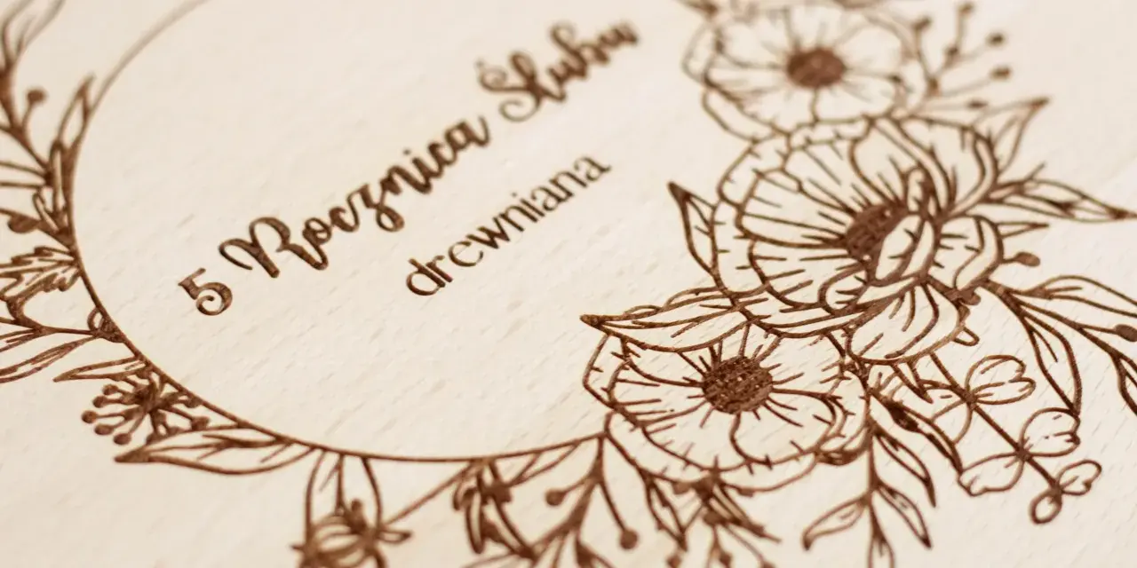 Drewniana tabliczka z wygrawerowanymi kwiatami i napisem "5 Rocznica Ślubu drewniana".