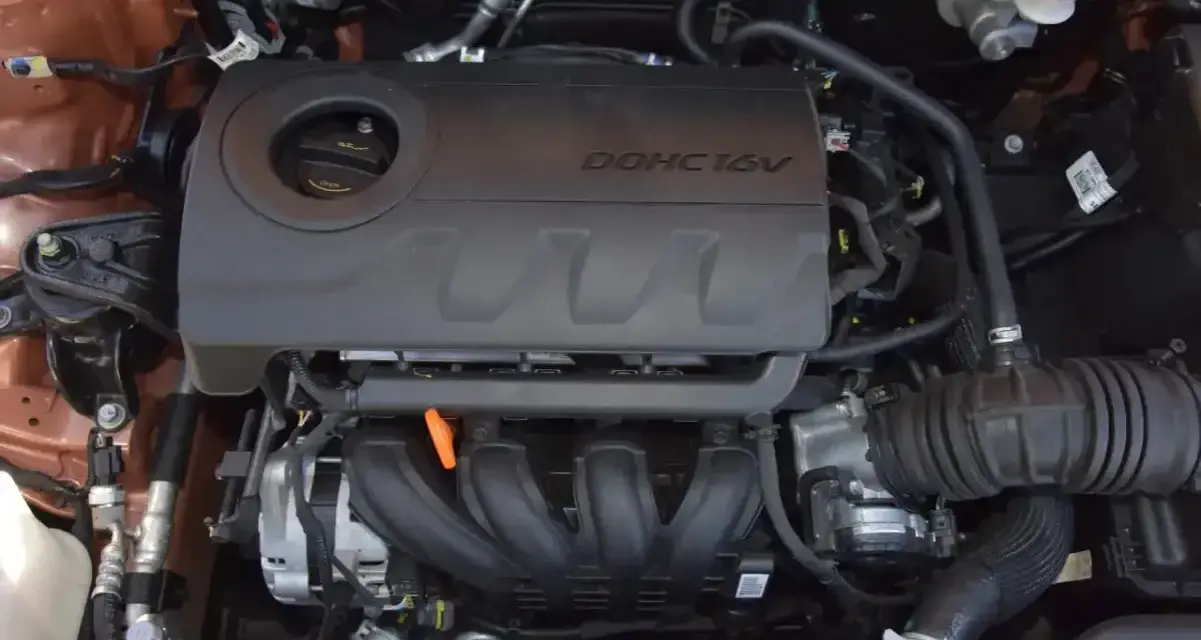 Silnik 1.4 MPI DOHC 16V w samochodzie. Widoczne elementy układu dolotowego i osłona silnika.