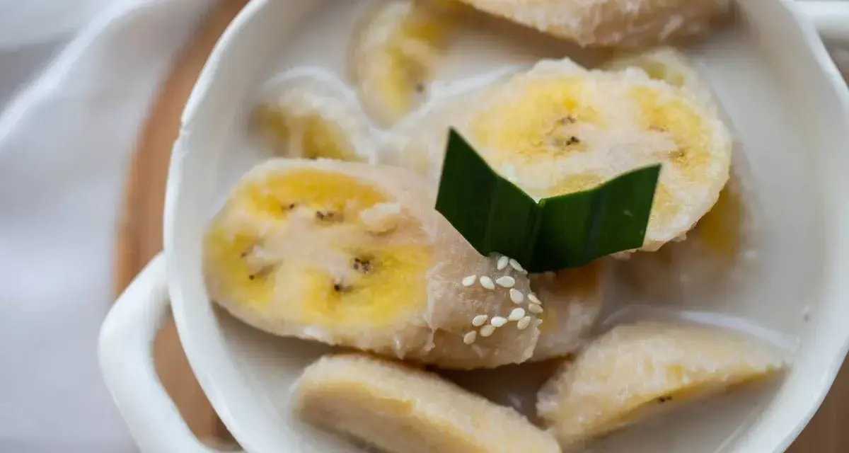 Kawałki banana w mleku kokosowym, ozdobione liściem pandanu i sezamem. Pyszny tajski deser.