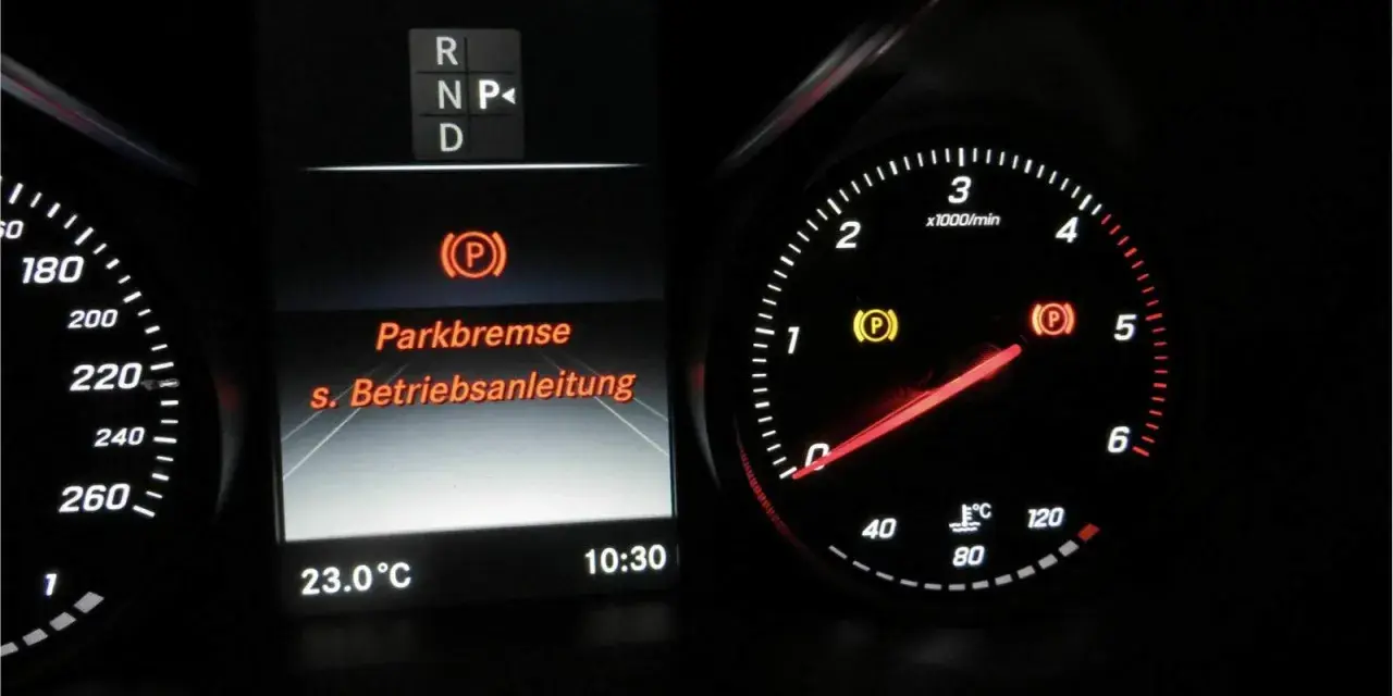 Mercedes-Armaturenbrett: gelbe Warnleuchte für die Feststellbremse leuchtet. Die Anzeige "Parkbremse" und "s. Betriebsanleitung" ist sichtbar.