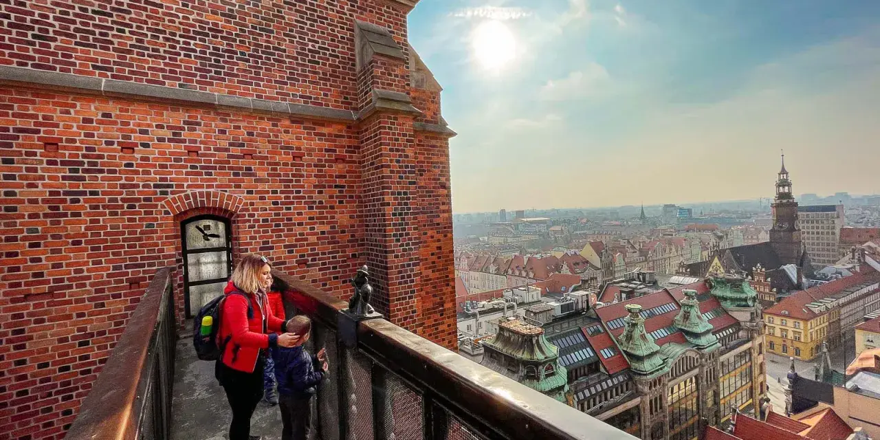 Kobieta z dzieckiem na moście pokutnic, podziwiający panoramę miasta.