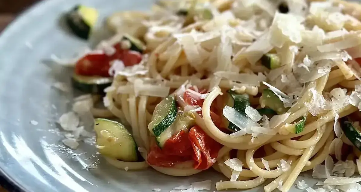 Pyszny makaron z pomidorkami koktajlowymi, cukinią i parmezanem. Idealny letni posiłek.