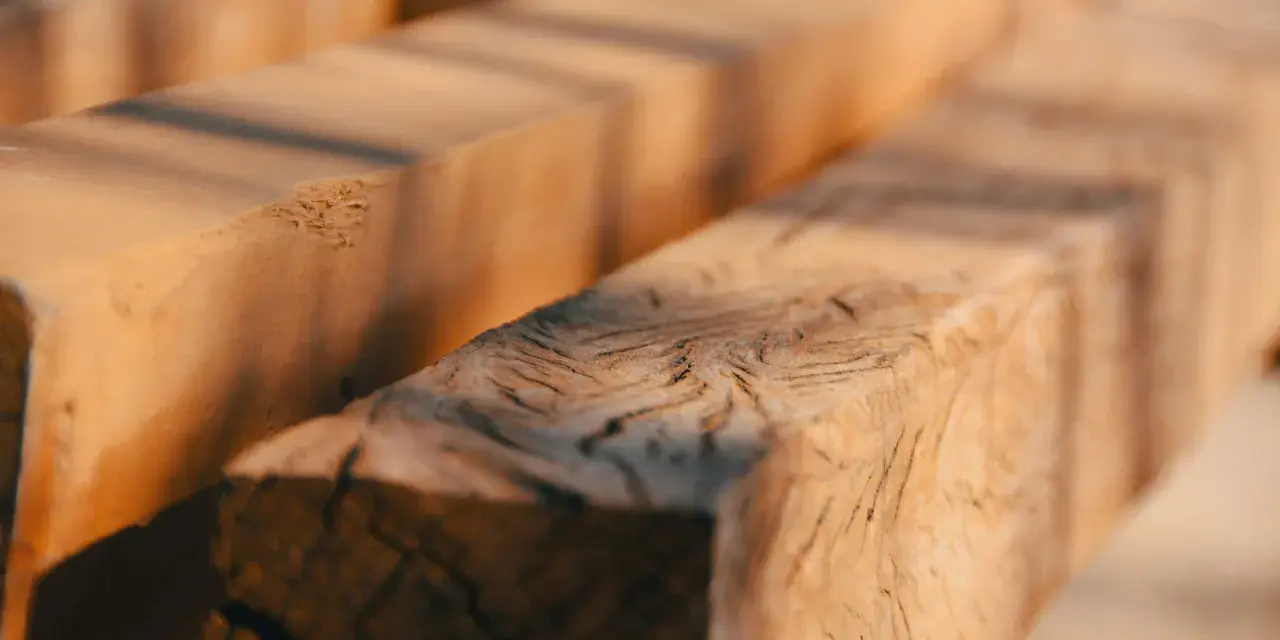 Close-up of rough-hewn wooden beams, evoking the question: was Jesus a carpenter?