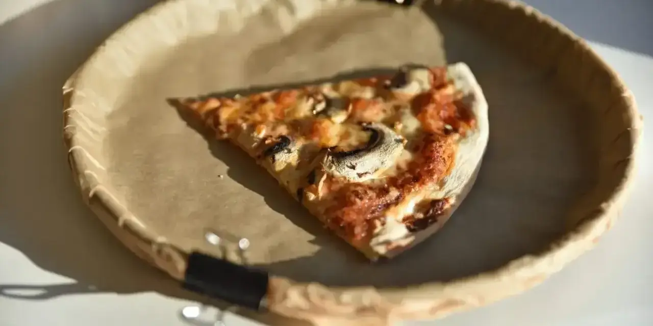 Kawałek pysznej pizzy capricciosa z pieczarkami i serem, idealna na szybki lunch.