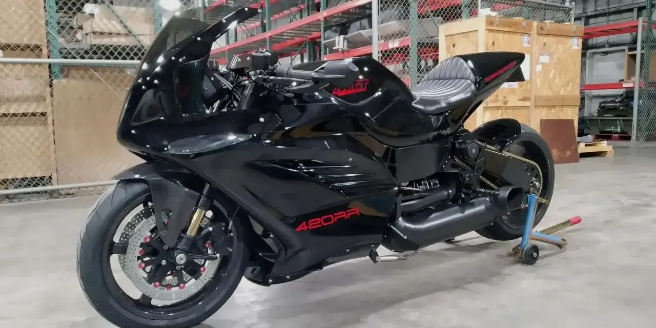 Moto nera lucida, la 420RR, con logo rosso sul serbatoio. Potrebbe essere la moto più veloce al mondo, pronta a sfrecciare.