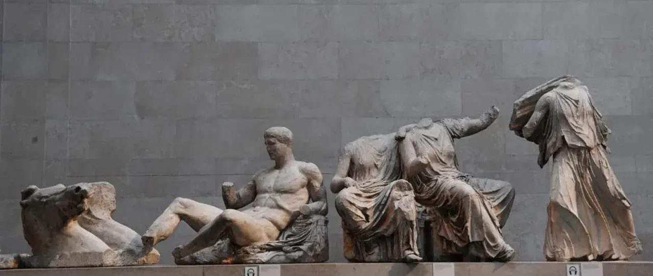 Statues grecques antiques, dont un homme musclé assis et des figures féminines drapées, témoignant de l'art hellénistique.