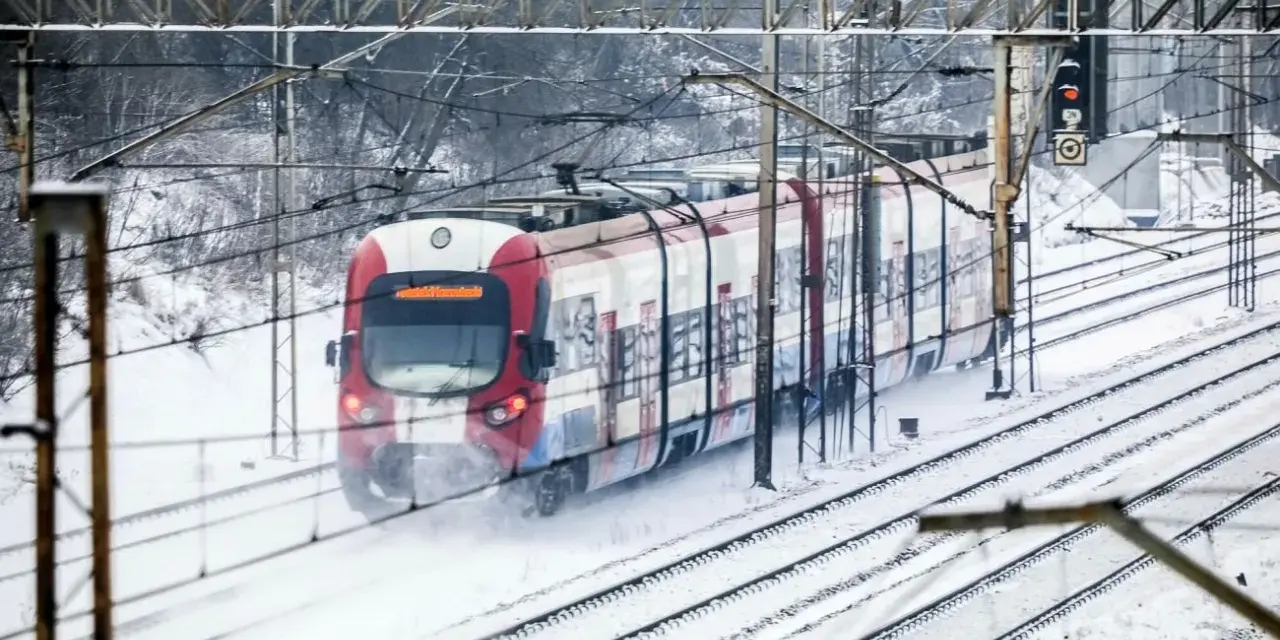 Pociąg w śniegu, mimo strajku maszynistów, jedzie po torach.