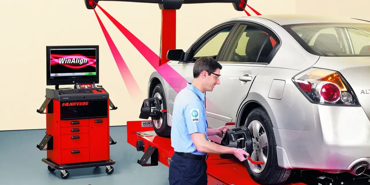 Tecnico esegue convergenza gomme con sistema Hunter WinAlign. Misurazione laser per assetto perfetto.