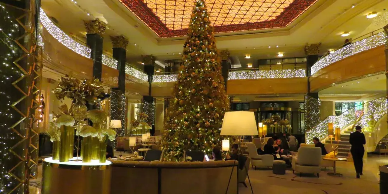 Elegancka wigilia w hotelu. Ogromna choinka i złote dekoracje tworzą świąteczną atmosferę.