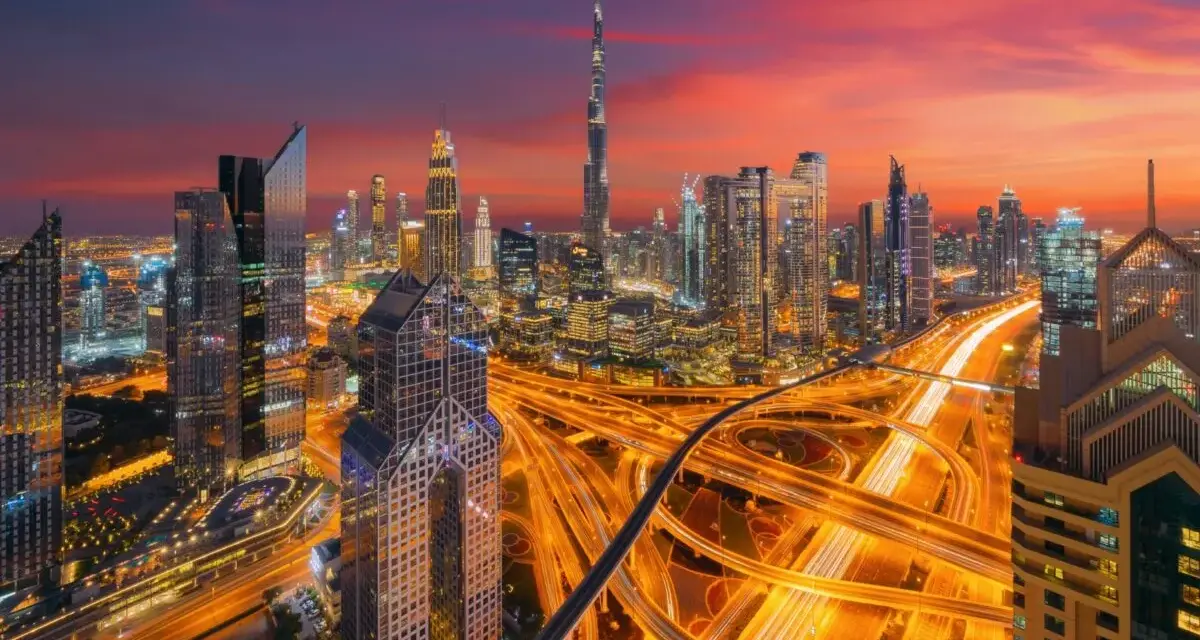 Wieczorny widok na Dubaj z drapaczami chmur i autostradą. W tle widać Burdż Chalifa. To miasto, gdzie kwitnie handel i **waluta Dubaju** jest symbolem rozwoju.