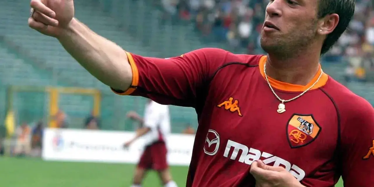 Antonio Cassano w koszulce Romy, z palcem wskazującym w górę, celebruje bramkę.