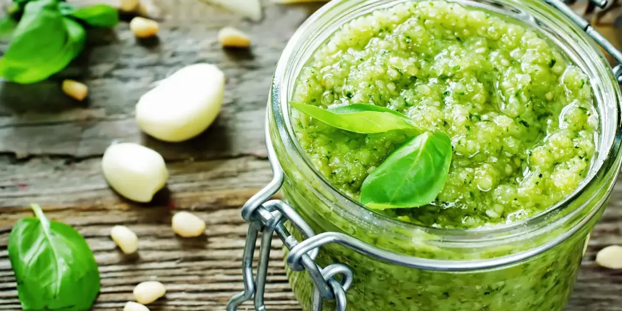 Frisches Pesto machen: Basilikum, Pinienkerne, Knoblauch und Parmesan auf rustikalem Holz.
