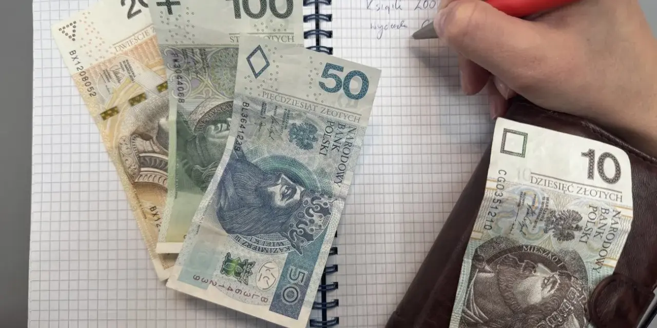 Zapisywanie wydatków na dziecko z orzeczeniem o potrzebie kształcenia specjalnego. Na zeszycie leżą banknoty 200, 100, 50 i 10 zł.