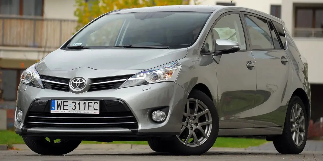 Srebrna Toyota Verso 1.8 benzyna zaparkowana przed domem.