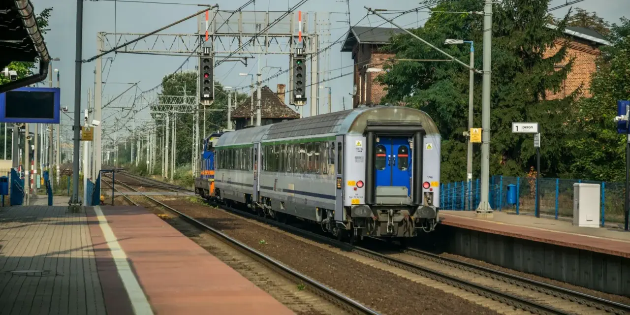 Pociąg Polregio z wygodnymi miejscami siedzącymi stoi na peronie.