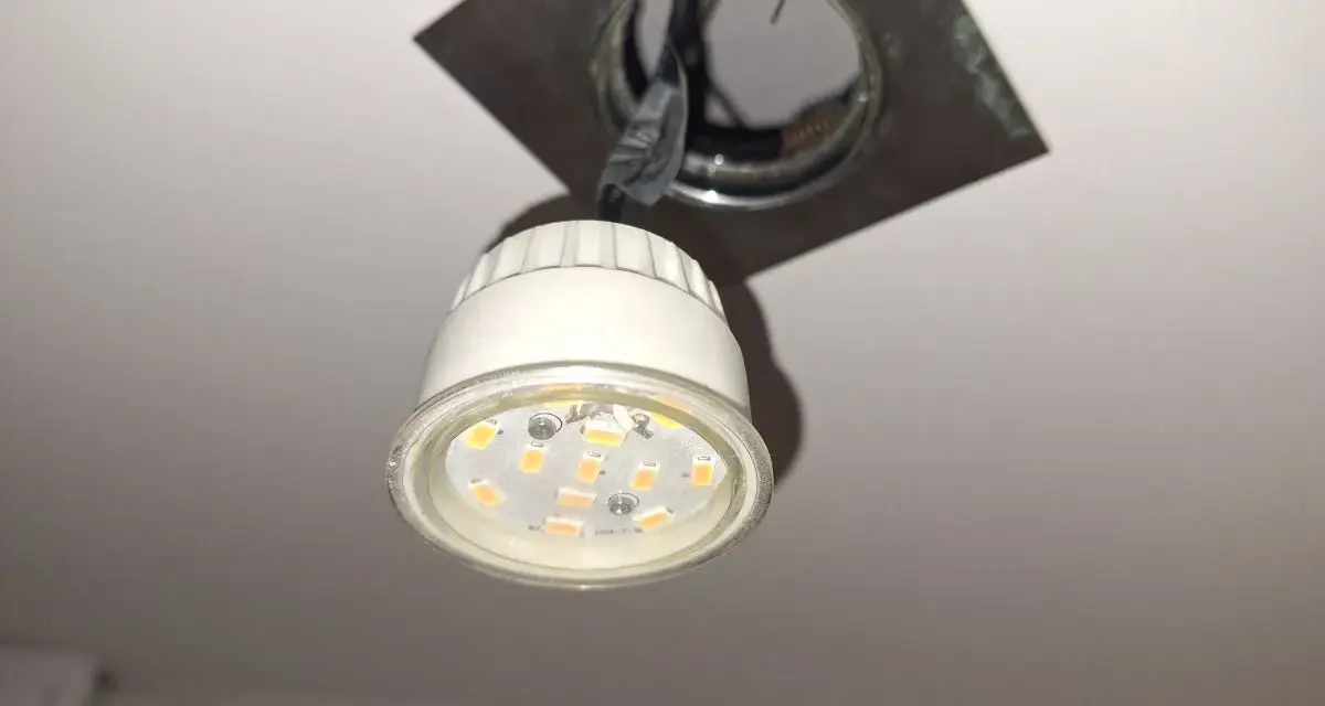 Wymiana żarówki led w oprawie sufitowej. Nowa, energooszczędna żarówka czeka na montaż.
