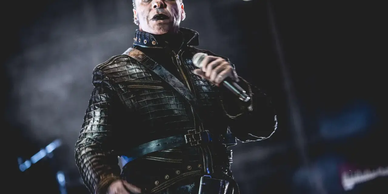 Till Lindemann w skórzanej kurtce, z mikrofonem w dłoni, jakby opowiadał historię swojej żonie.