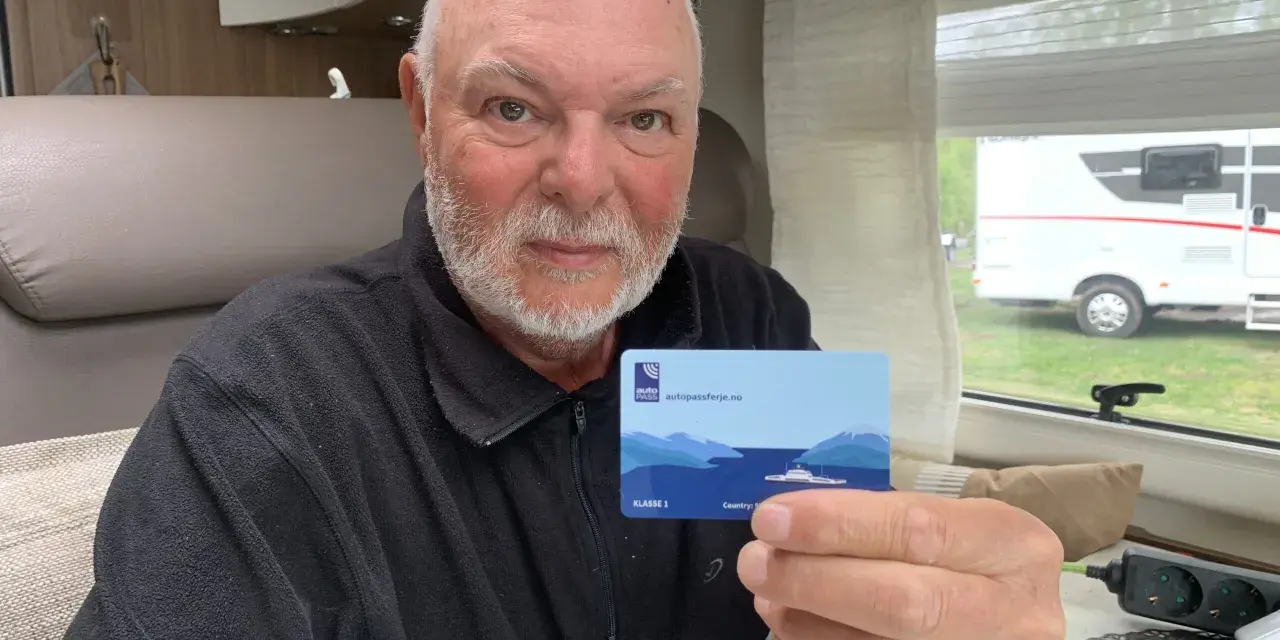 Man håller upp ett kort med texten "autopassferje.no", redo för resor mellan Norge och Sverige.