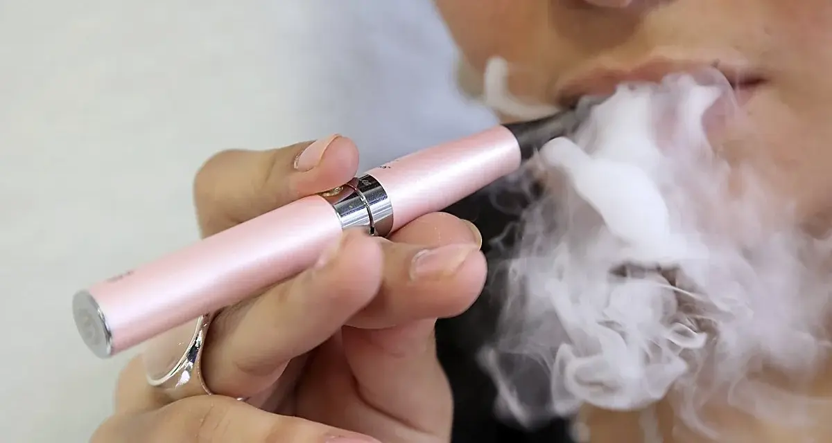 Persona usa un vapeador para dejar de fumar, exhalando una gran nube de vapor.