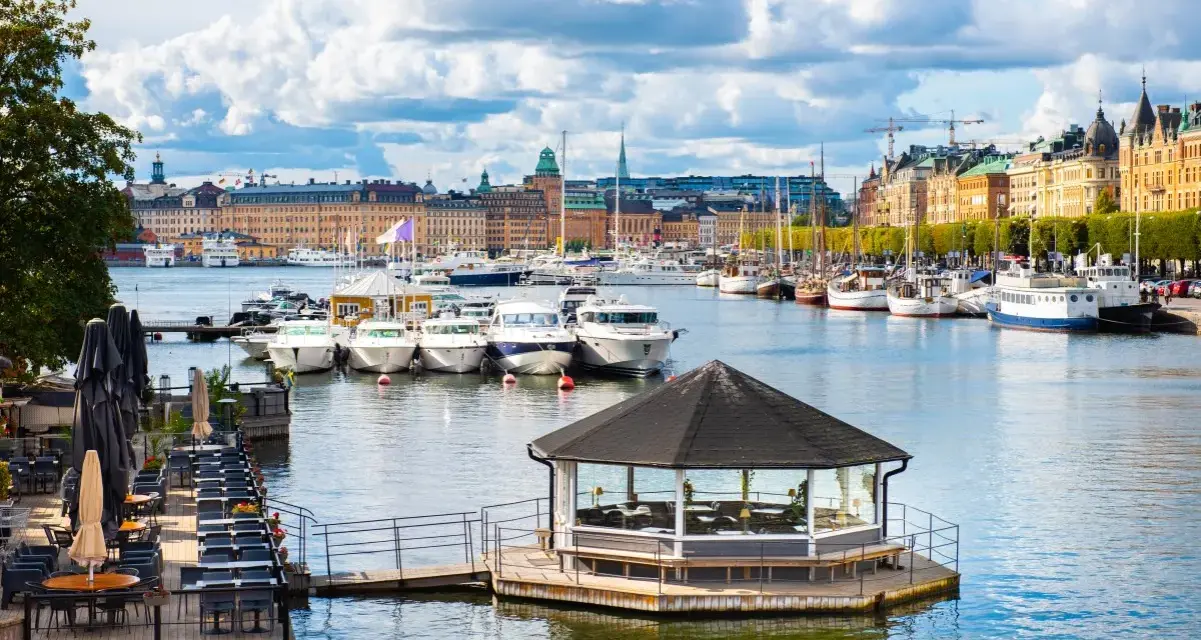 Widok na port w Sztokholmie, z łodziami i budynkami w tle. To jedno z szwecja najpiękniejsze miejsca.