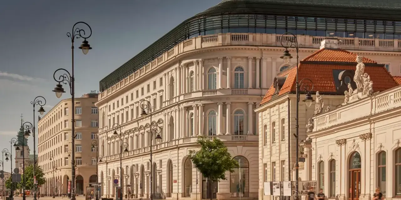 Elegancka kamienica z nowoczesnym dachem, być może najdroższy hotel w Polsce, przy słonecznej ulicy z zabytkowymi latarniami.