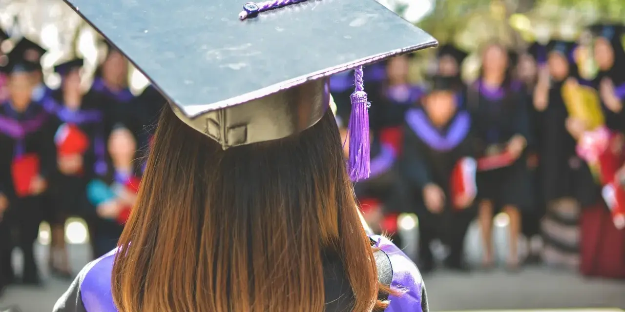 Laurea in fisica, ma il futuro è incerto. Un gruppo di laureati in fisica disoccupati attende il proprio destino dopo la cerimonia.