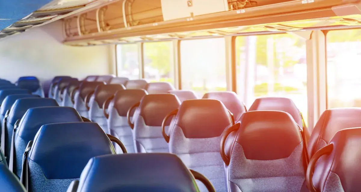 Puste siedzenia w autobusie lub pociągu z widokiem przez okno.
