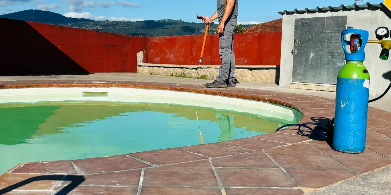 Técnico trabajando en el borde de una piscina, con equipo para impermeabilizar piscina.