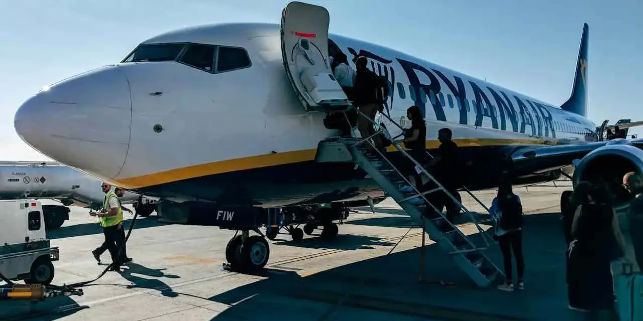 Ryanair samolot, pasażerowie wsiadają. Pamiętaj o zasadach, jak przewozić leki w samolocie Ryanair, by podróż przebiegła sprawnie.