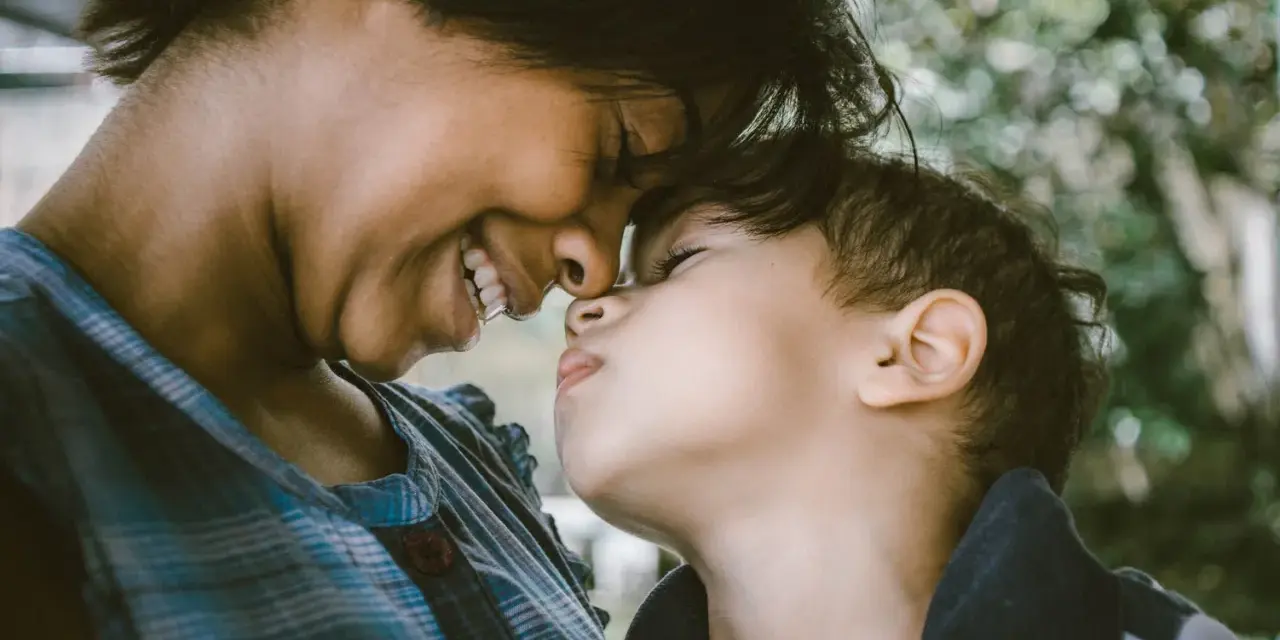 Ein inniges Lächeln verbindet Mutter und Kind. Ihre Nasen berühren sich, ein Moment purer, unendlich liebe zum Kind.