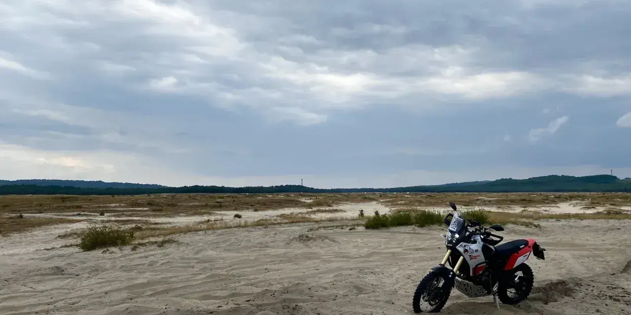 Motocykl na piaszczystym terenie, idealny na szlak Orlich Gniazd samochodem trasę.