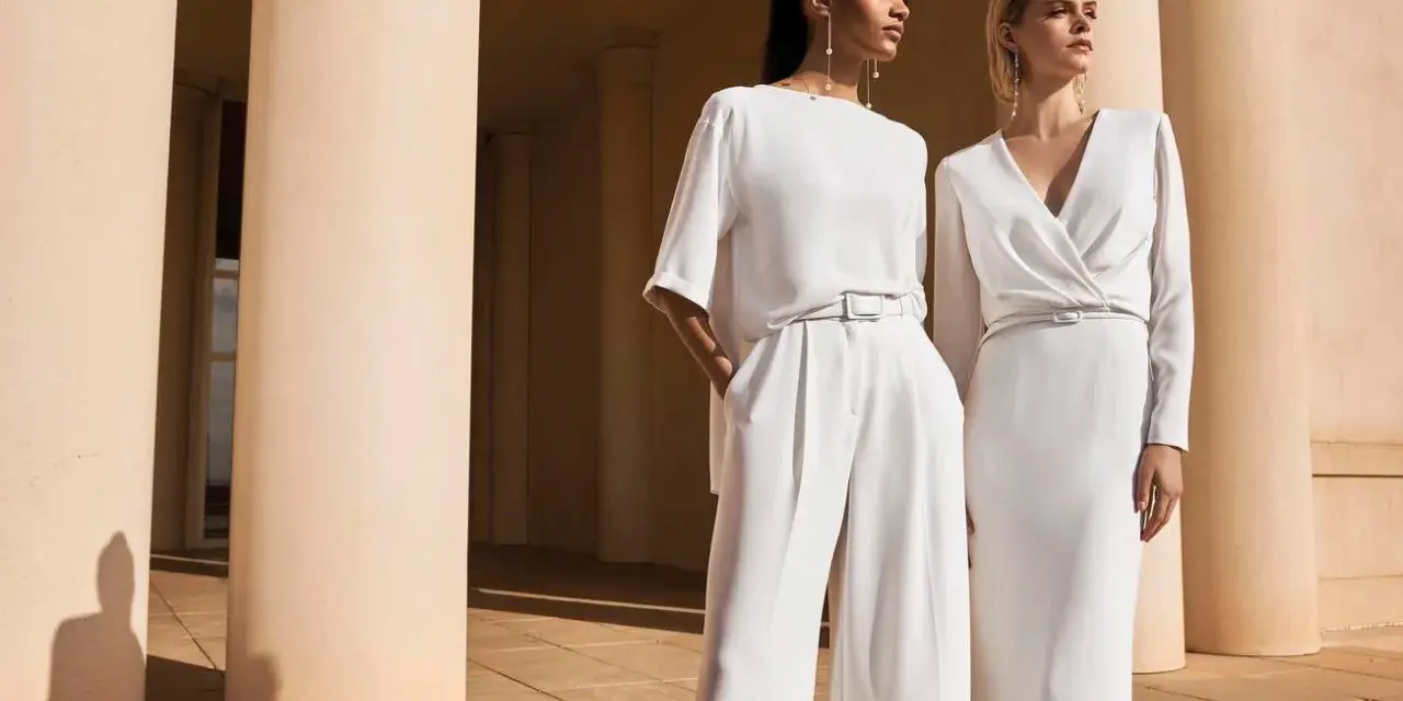 Eleganza senza tempo: come vestirsi ad un matrimonio a 50 anni con pantaloni palazzo e abito longuette in bianco.