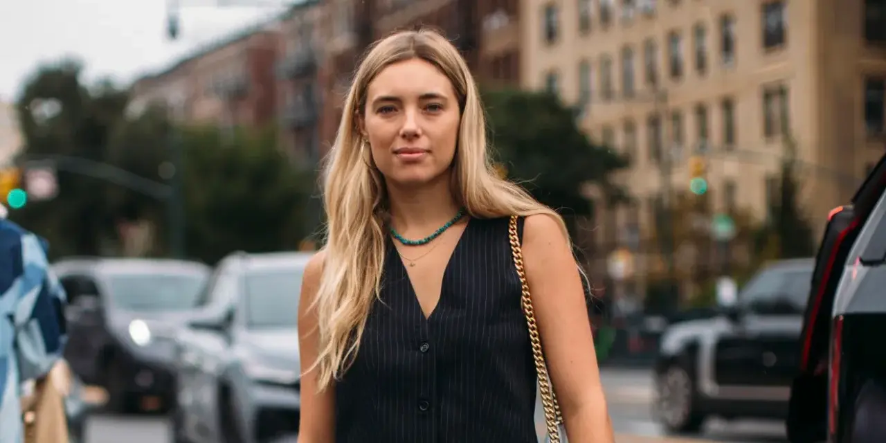 Donna con panciotto gessato, un accessorio che aggiunge un tocco di stile e raffinatezza. Il suo significato è eleganza e audacia.