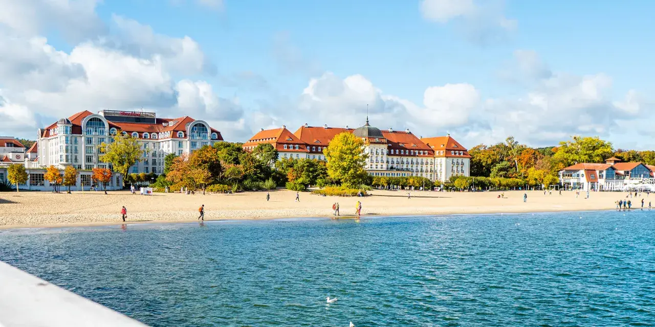 Piękne, nadmorskie miejscowości zachwycają architekturą i plażą. Spacerowicze cieszą się jesiennym słońcem.