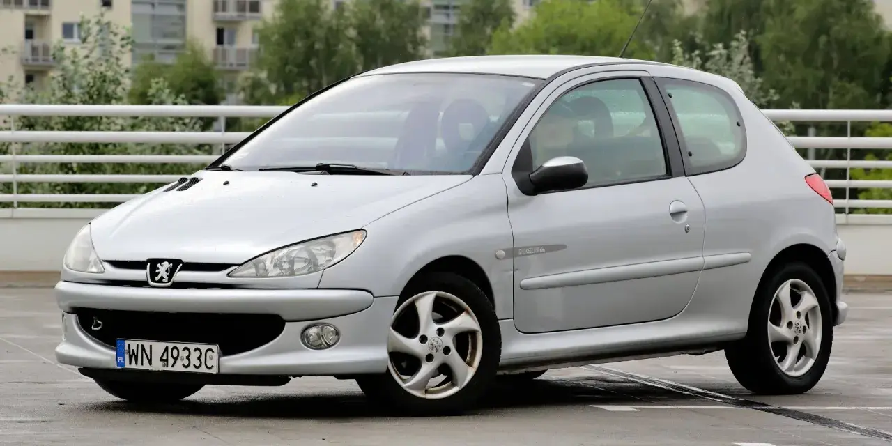 Srebrny Peugeot 206 1.4 benzyna na parkingu.