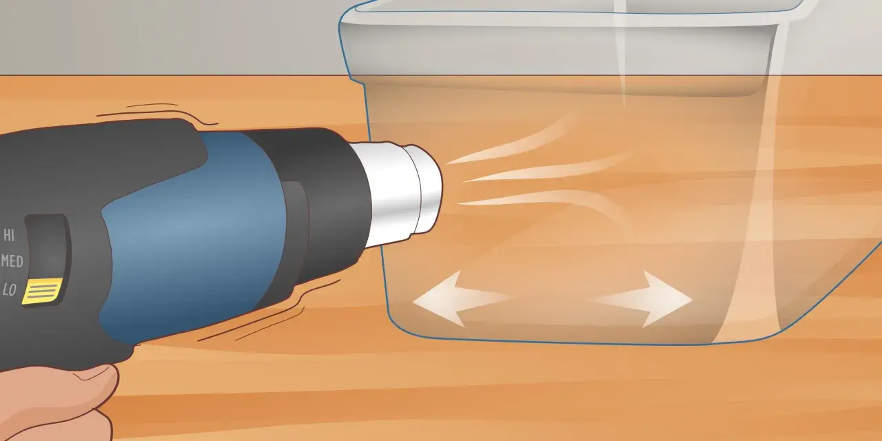 A heat gun is used on low setting to gently warm a scratched plexiglass surface, showing how to get scratches out of plexiglass.