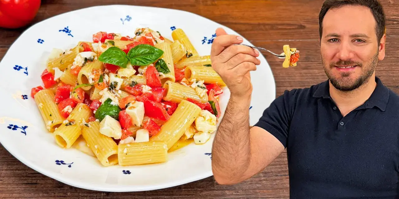 Un uomo sorride mentre assaggia una forchettata di pasta alla checca, un piatto fresco con pomodori, mozzarella e basilico.