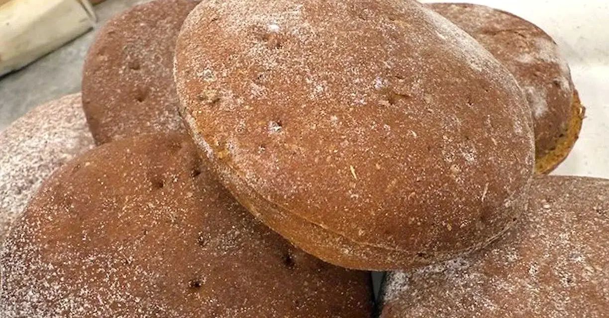 En hög med nybakade rågkakor, perfekta för ett enkelt rågkaka recept. Strödda med lite mjöl.