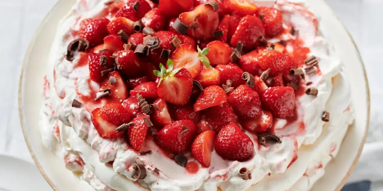 Ein köstliches Pavlova Rezept mit frischen Erdbeeren und Schokostreuseln.