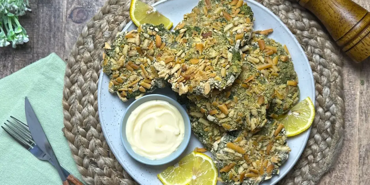 Spinacine fatte in casa croccanti, servite con maionese e spicchi di limone. Un piatto gustoso e salutare.