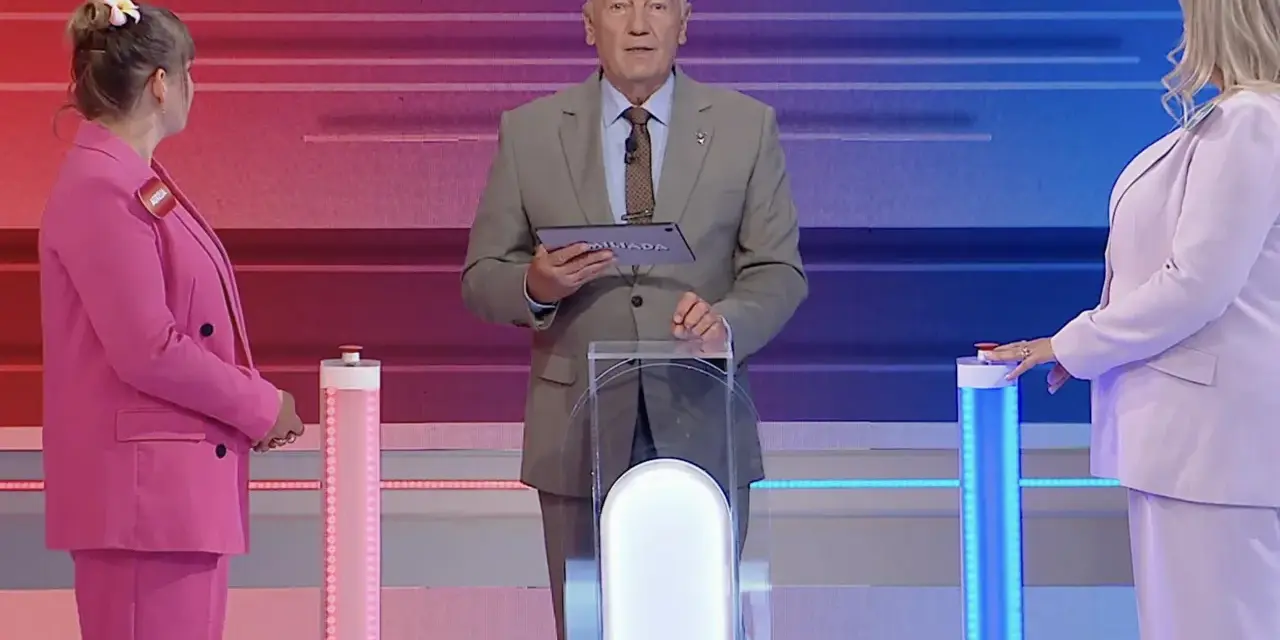 Prowadzący Familiady z tabliczką "Miliada" i dwie uczestniczki w różowych strojach. Zastanawiają się, co zmieniamy podczas jazdy samochodem.