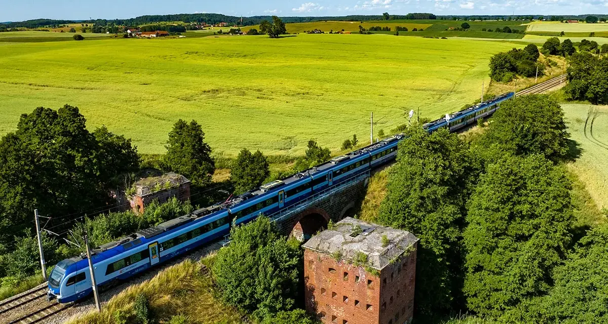 Pociąg mknie przez zielone pola, mijając stare forty. Idealny sposób, by dowiedzieć się, gdzie na Mazury pociągiem.