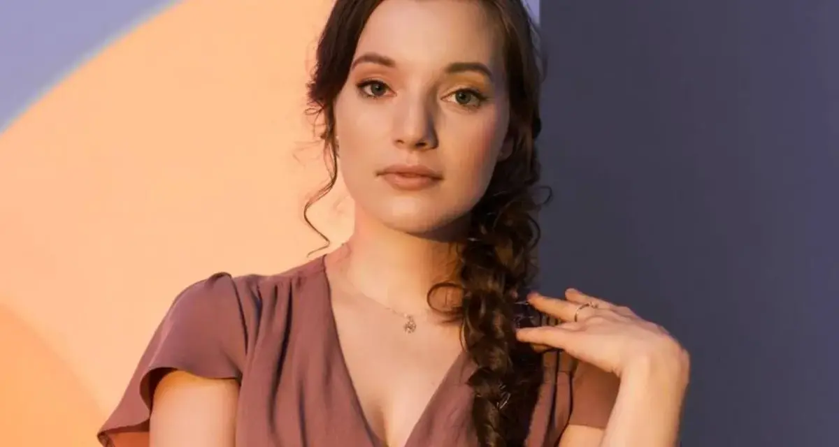 Sanah w The Voice of Poland przesłuchania. Młoda artystka w różowej sukience z warkoczem.