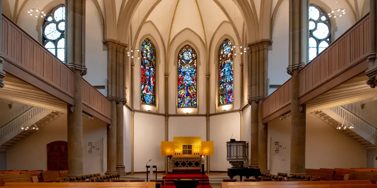 Festlicher evangelischer Gottesdienst am Heiligabend in einer Kirche mit Buntglasfenstern und Holzbänken.