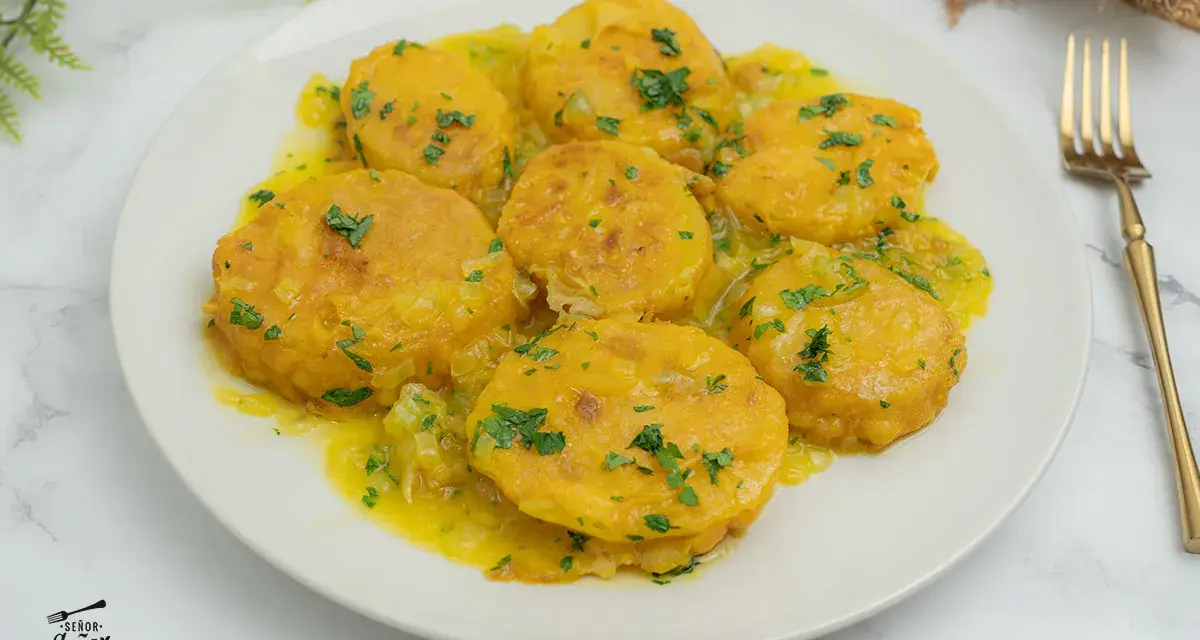 Patatas a la importancia, doradas y tiernas, bañadas en una salsa amarilla con perejil picado. Un plato que demuestra la importancia de las patatas en la cocina.